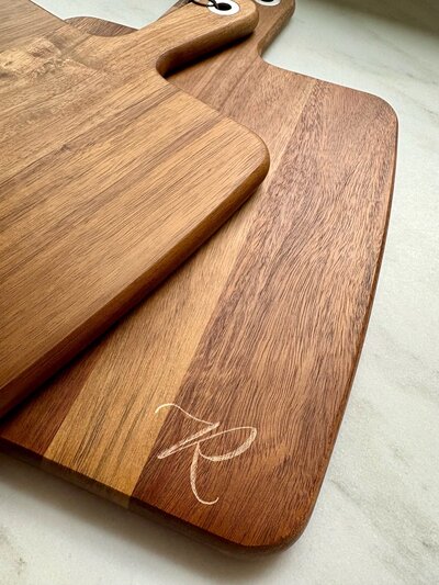 Hand engraved wood cutting board with calligraphy monogram.