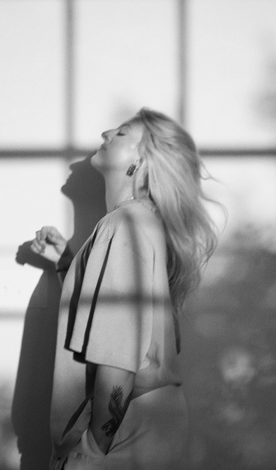 black and white image of side profile of Kaylin in the middle of a hair flip