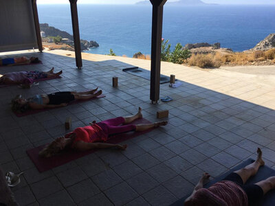 A tranquil retreat atmosphere with guests relaxing and practicing yoga outdoors.