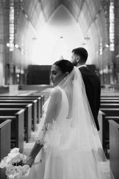 Black and white documentary photographer of groom and bride at a large historical chapel wedding | Sush Digital Media