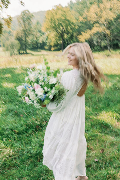 Local florist Savanna of Oopsie Daisy florals spending time outdoors with a custom real flower wedding bouquet,