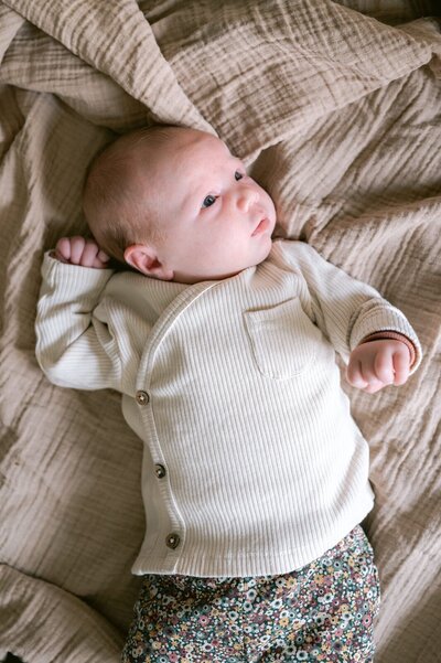 Newborn ligt op kleedjes op bed 