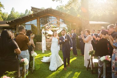 Bride and Froom walk down the aisle as guests applaud at The San Moritz Lodge