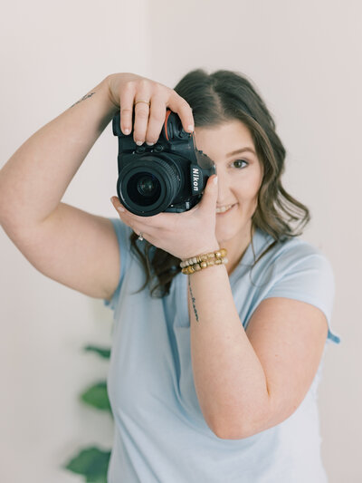 Maryland maternity, newborn, and family photographer holding her camera for branding shoot.
