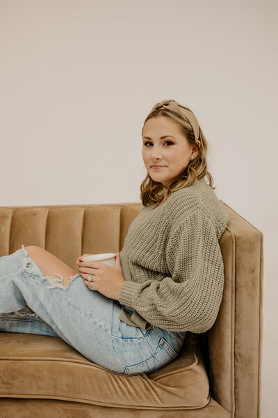 Woman sitting on stool in blazer