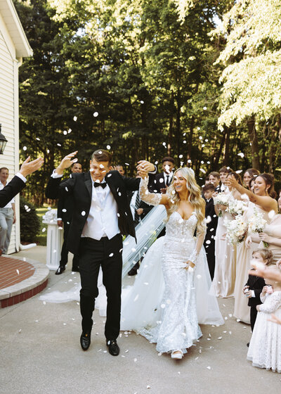 Groom spinning bride in wedding dress in the middle of a tree lined road