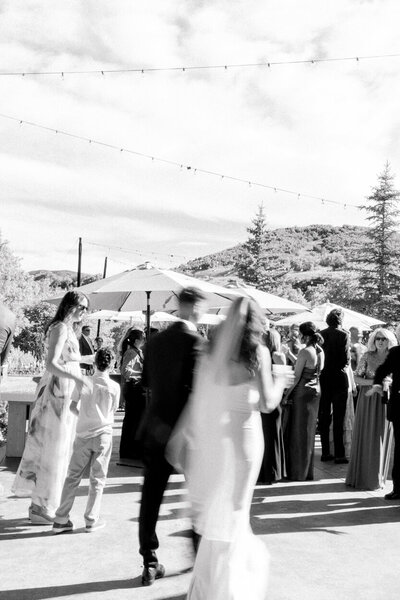 bride and groom with reception in the background