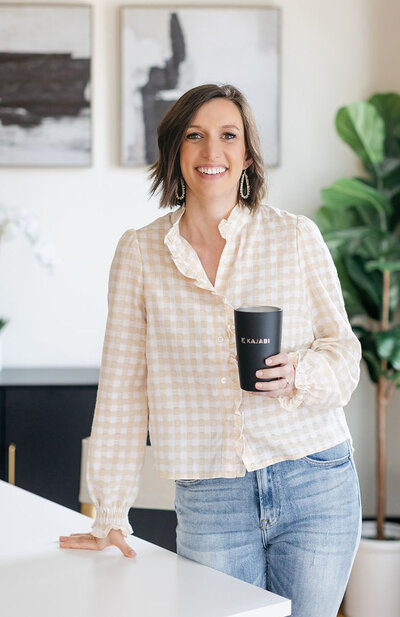 Chelsea Hayes of Just Launch standing with kajabi mug