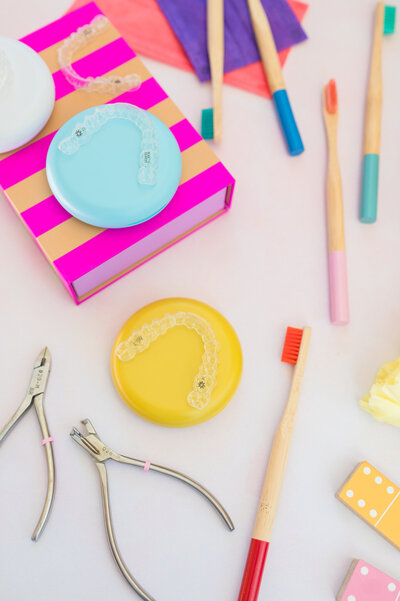 Flatlay of assorted brightly colored ental and orthodontic tools