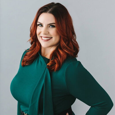 red haired woman with green shirt posing with hand on her hip