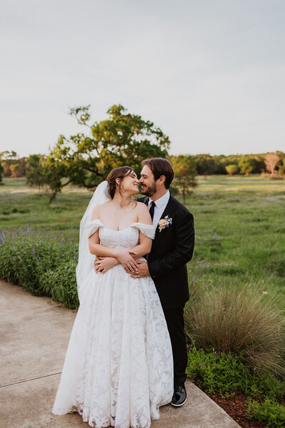 A couple poses for photos at the LBJ Wildflower Center wedding in Austin, Texas