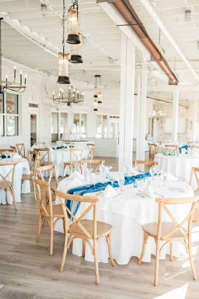 A wedding reception hall with circular tables in an open room