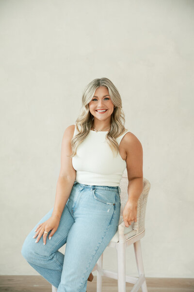 A woman named Tessa, a content creator from Ohio, sits on a couch holding an iPhone.