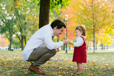 A two year old giving a leaf to her father