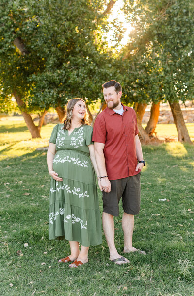 Expecting mom holding her baby bump in a field of lavender for maternity photos in st george utah