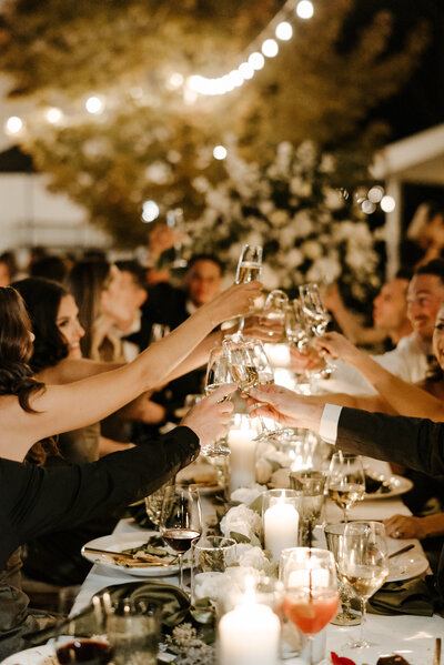 photo of reception table with people toasting with champagne