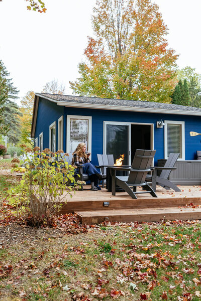 Blue lake house with deck and patio chairs