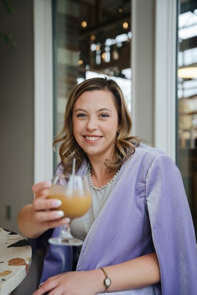 Jordan Schram, founder of Purple Sky Strategy, smiling in a pink blazer.