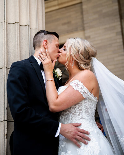 The bride and groom kissing outside of their wedding near Delaware Park in Buffalo, NY.