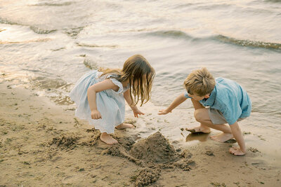 two young children making a sandcastle. Photos by Chicago family photographer Kristen Hazelton