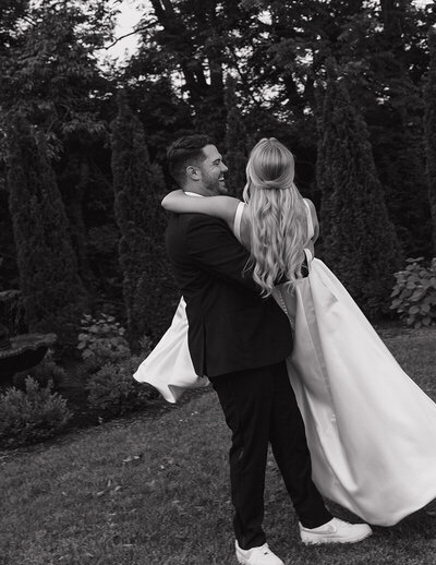 A bride and groom share a loving embrace in a lush garden during their wedding celebration.