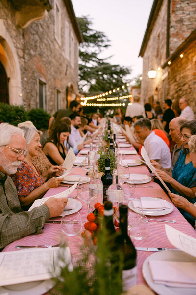 Photo of a long table from top to bottom during the welcome dinner for a wedding we shot in Tuscany Italy