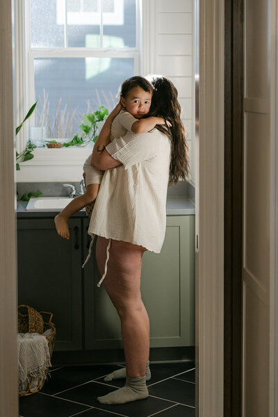 Woman with child in bright laundry room