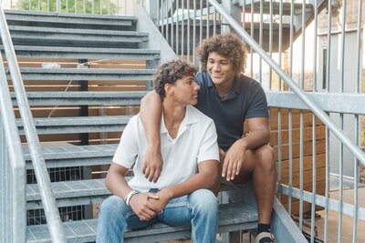 a guy sitting with his arm around his twin brother