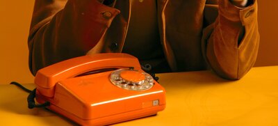 Orange dial phone on a table
