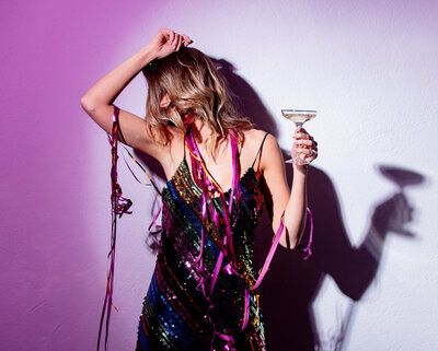 Girl boss holding martini and dancing in joy