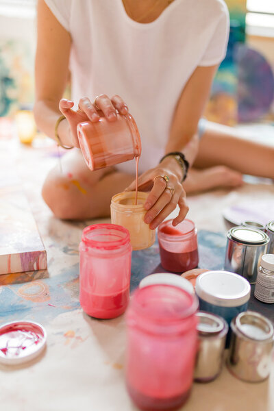 Close-up of Courtney Claire Beglin mixing paint colors in her art studio