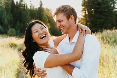Couples photographer located in Rexburg Idaho. An engaged couples smiles at the camera, the man looking at his fiance and the woman is looking at the camera.