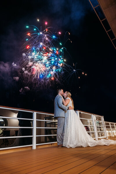 A colorful explosion of fireworks lights up the sky as the newlyweds embrace on the Disney Wish deck during their wedding night.