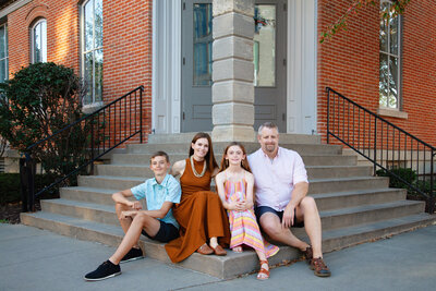 Family of four sitting on stairs in Iowa City, Iowa.