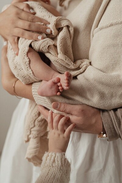 Newborn cradled in mother’s arms photographed by West Michigan photographers