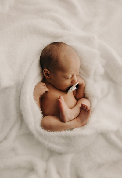 Beautiful sleeping newborn baby in a cozy white outfit during a Mullingar photoshoot