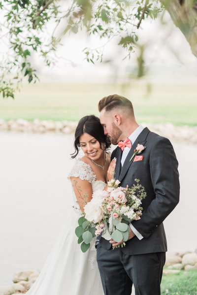 wedding photo of couple standing in front of a pond