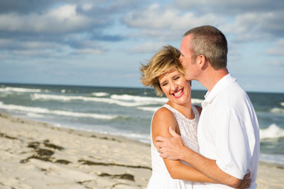 couple laughing with ocean in back