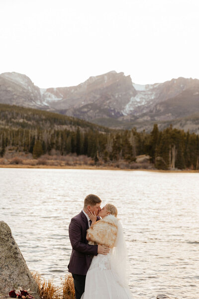 First kiss between bride and groom during Sprague Lake elopement in Rocky Mountain National Park