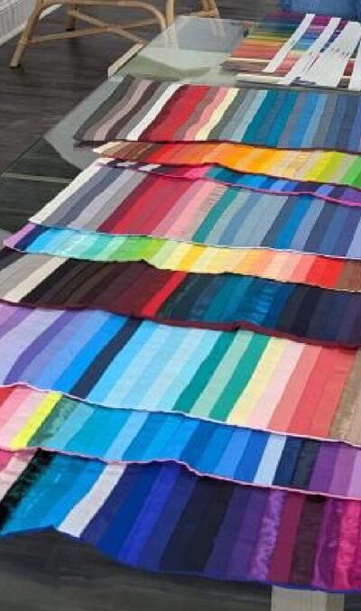 Rows of colorful fabric swatches used in personal color analysis, shown in soft lighting for visual reference