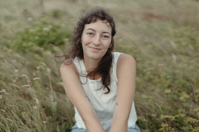 Heather smiles serenely in a meadow of tall grass