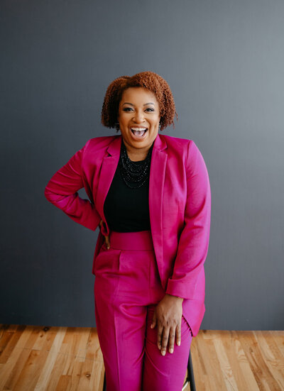 woman in bright pink suit laughing
