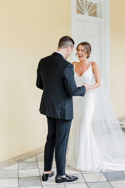 candid black and white photo of bride & groom entering their reception