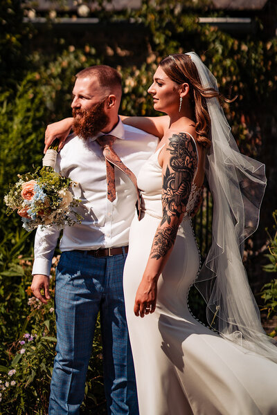 Groom is wearing a tux and bride is wearing a white dress outside on Islington Town Hall