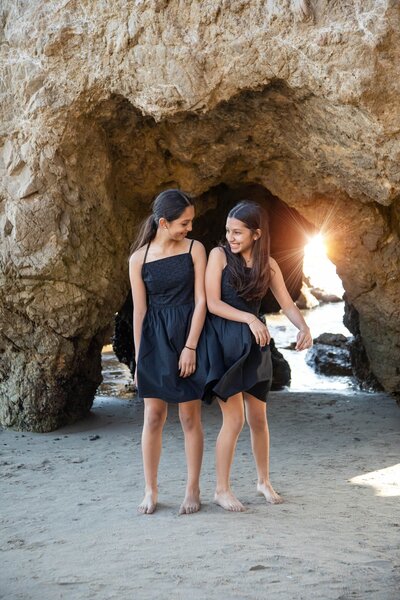 Two kids hip bumping each other on beach | Family Photography