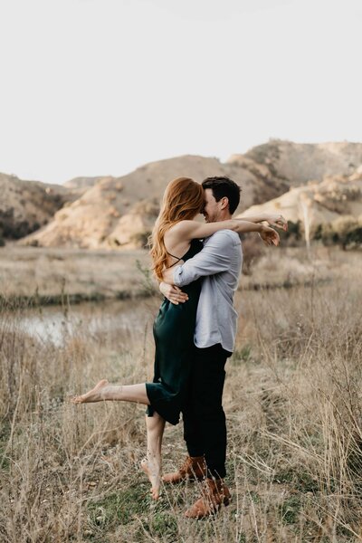 couple kissing and holding eachother in nature
