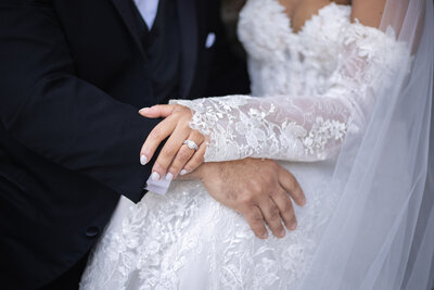 Elopement Wedding Packages Rhode Island | Kelsey Sheehan Photography Timeless Rhode Island Weddings | Bride and groom's hands rest gently on each other. Bride's lace dress and diamond ring are visible, conveying elegance and intimacy.