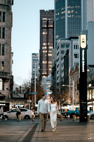 Hayden and Susan walking through Auckland city streets during engagement photoshoot, captured by Zanthe Vorsatz Photography.