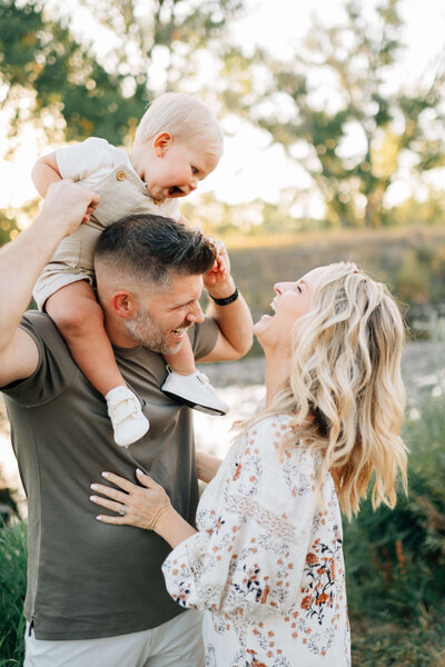 baby on dad's shoulders smiling at mommy