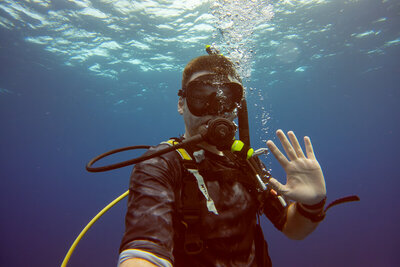 Nathan Sottung waves to the camera while completing his scuba open water certification in Belize, where he encountered sharks, eels, stingrays, and vibrant marine life, showcasing his adventurous spirit